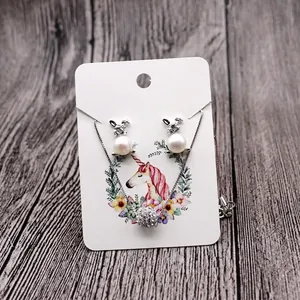 Detail of bunny pearl earrings and sparkling ball necklace on a floral display card
