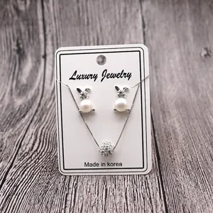 Luxury bunny pearl earrings and sparkling rhinestone sphere pendant necklace set on card