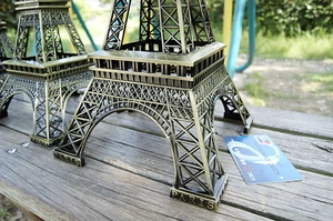 Dettaglio del modello vintage della Torre Eiffel in bronzo con incisioni di Parigi sulla base