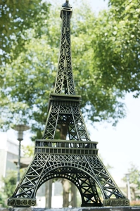 Primo piano del souvenir in metallo della Torre Eiffel in bronzo con incisione PARIS e parco