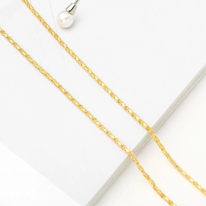 Elegant gold chain accessory for sunglasses and eyeglasses on white textured surface