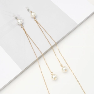 Elegant gold chain eyewear strap with white pearls on a minimalist magazine background