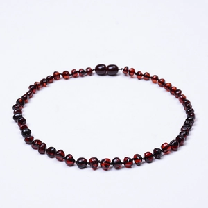 Detailed view of dark red Baltic amber necklace featuring irregular beads and a screw clasp