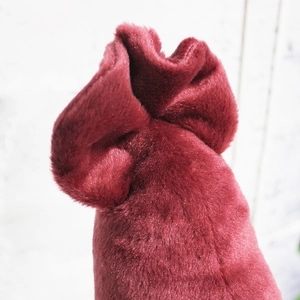 Detailed macro shot of the soft burgundy plush fabric and top texture of squid toy