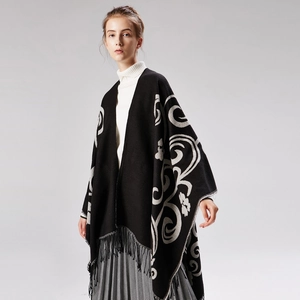 Thick knitted shawl with black tassels and abstract silver patterns on a female model