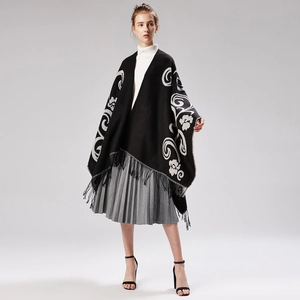 Detail of black cashmere shawl with white floral embroidery and tassel fringe