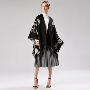 Detail of floral pattern and fringe hem on a warm knit shawl cape for women