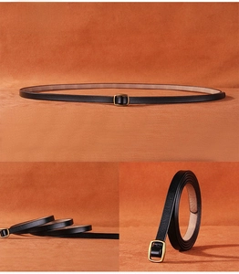 Detail view of thin black leather belt with gold square buckle on orange velvet background