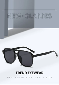 Detail view of large square black sunglasses featuring gold rivets and double bridge frame