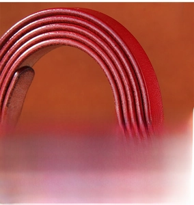 Macro shot of red leather belt edges showing the refined oil edge coating process