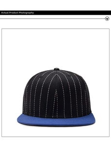 Detail of flat brim baseball cap with black pinstripe crown and blue contrast visor