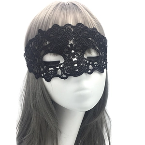 Close-up of black lace masquerade mask with intricate cutout patterns on a white mannequin