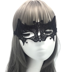 Detail of bat-wing shaped black lace party mask with intricate hollow-out eye design