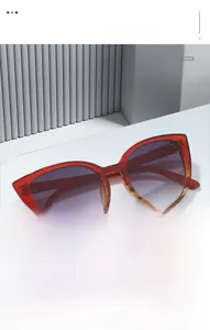 Detail of red and amber gradient cat-eye sunglasses with gradient purple lenses