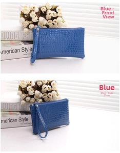 Detailed view of blue crocodile pattern wristlet clutch with metal zipper and strap