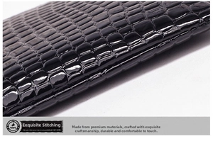 Detail of black crocodile texture leather pouch featuring high-gloss finish and fine stitching