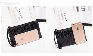 Size comparison of a black crocodile pattern clutch bag next to a smartphone