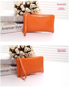 Orange wristlet clutch with crocodile embossed leather texture and gold zipper detail