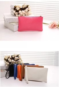 Detail of crocodile pattern clutches in various colors with wristlets and zippers