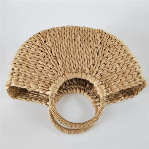 Close-up of semi-circular straw woven bag with dual round handles and natural textures