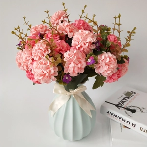 Pink artificial hydrangea bouquet in light blue striped vase with white ribbon bow