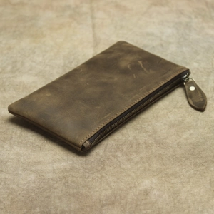 Gros plan détaillé d'un portefeuille en cuir marron foncé montrant des textures vintage