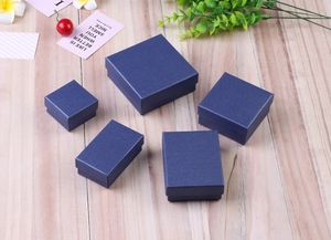 Linen textured dark blue jewelry box collection for rings and necklaces on wood