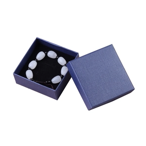 Blue textured jewelry gift box containing a white bead bracelet with black accents