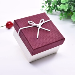 Macro detail of wine red textured jewelry box lid with white bow and silver base