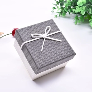 Top view of a square textured gift box with grey-white color blocking and a white bow
