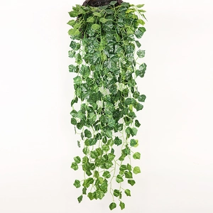 Close-up of artificial hanging ivy vines with lush green leaves in a woven basket