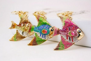 Detailed view of three colorful crystal fish keychains with enamel and metal plating