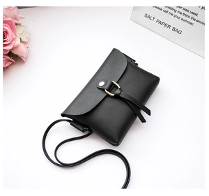 Detailed top view of a black mini leather phone bag with elegant gold hardware on white background