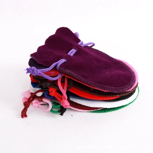 Close-up of multicolored velvet drawstring jewelry pouches in various vibrant colors
