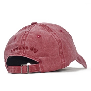 Close-up of vintage washed red cotton baseball cap with adjustable metal strap and embroidery