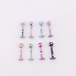 Detailed view of eight colorful paint-splattered stainless steel labret studs on white background