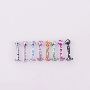 Detailed row of eight colorful splatter painted stainless steel lip and cartilage studs