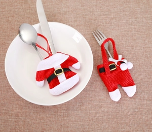 Detail of Christmas Santa clothes cutlery holder set on dark textured table
