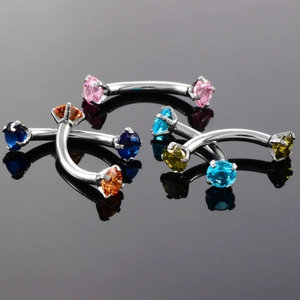 Close-up of curved stainless steel barbells with colorful zirconia stones for eyebrow piercing