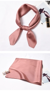 Close-up of elegant dusty pink satin square scarf with a smooth silky texture and glossy finish