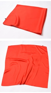 Close-up of a red satin square scarf showing smooth silk texture and elegant fabric sheen