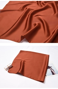 Close-up of caramel silk satin square scarf showcasing smooth texture and elegant luster