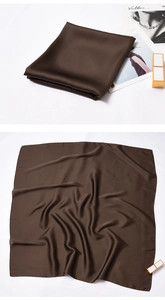 Detail of dark brown silk square scarf with satin gloss folded on a fashion magazine