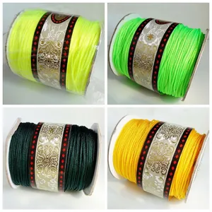 Detailed view of handmade DIY cord spools in neon yellow, green, and gold colors
