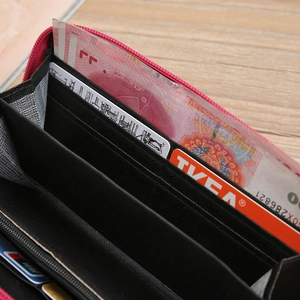 Detail of black embroidered long wallet interior showing multiple card slots and bellows design