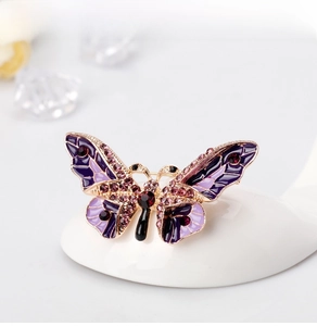 Macro detail of purple enamel butterfly brooch with sparkling rhinestones and gold alloy base