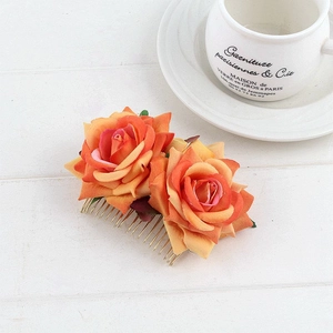 Close-up of dual gradient orange rose hair comb on a rustic white wood background