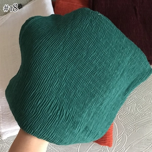 Detailed close-up of dark green pleated cotton linen scarf with fine vertical wrinkles