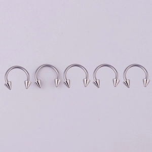 Row of five 316L stainless steel horseshoe rings with spiked ends on lavender background