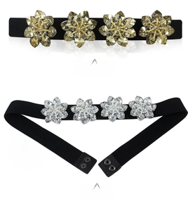 Detail of sunflower crystal embellishments on a black elastic waist belt for dresses